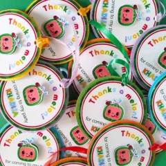 Vibrant Cocomelon-themed thank-you tags featuring layered cardstock in bright red, green, and yellow, personalized with a child’s name, perfect for kids’ birthday party favor bags or boxes.