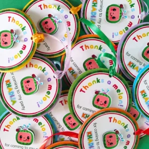 Vibrant Cocomelon-themed thank-you tags featuring layered cardstock in bright red, green, and yellow, personalized with a child’s name, perfect for kids’ birthday party favor bags or boxes.