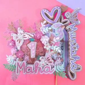 Featuring soft pastel tones, shimmering accents, and beautiful 3D elements, this topper is perfect for birthdays and other special occasions. It showcases your child's name and age in a charming, personalized style.